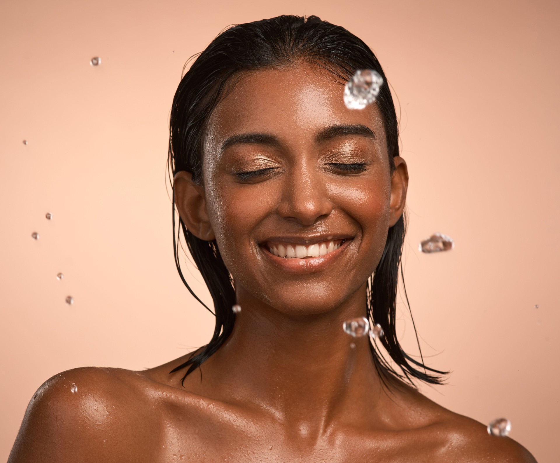 Shot of a young attractive woman doing her daily skincare routine against a brown background